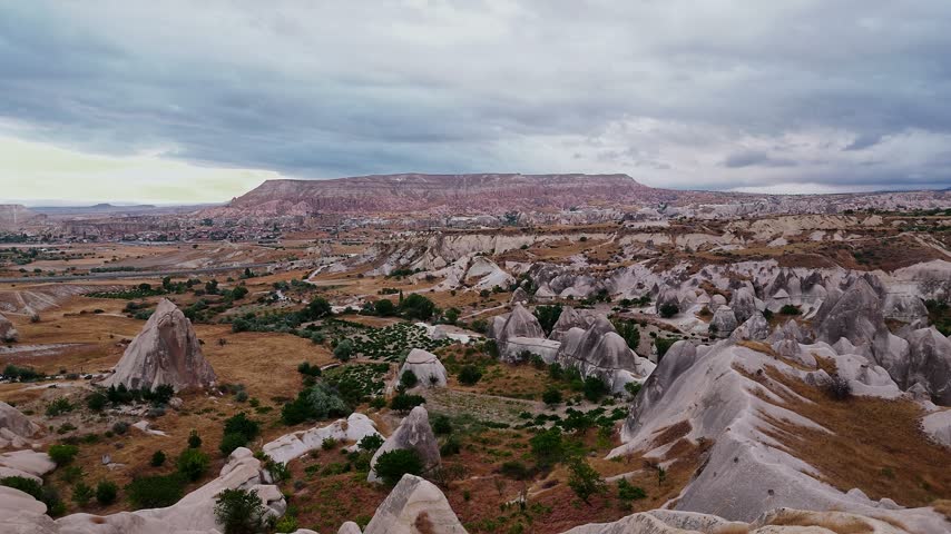 Wide view of Love Valley rock formations under cloudy sunrise skies in Cappadocia