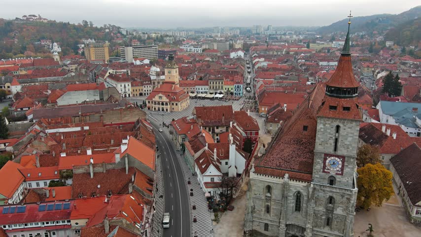 Aerial view of the historic Black Church and Piata Sfatului surrounded by red-tiled rooftops in the old town of Brasov, Brasov, Romania.