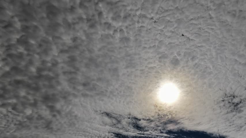 Aerial view of a blanket of speckled altocumulus clouds with the sun shining from behind in White Rock, NM, United States.