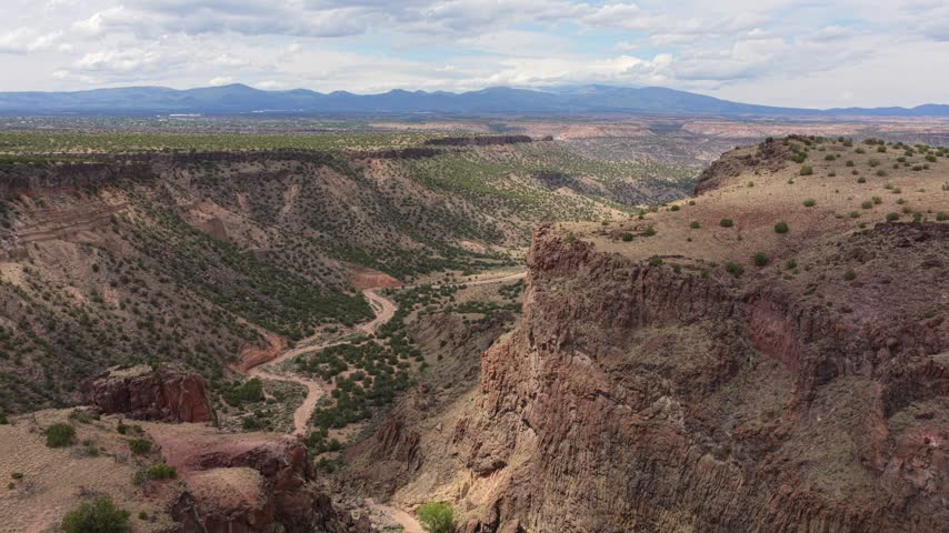 Aerial view of Diablo Canyon Recreation Area featuring rugged rocky cliffs and desert landscape under a cloudy sky in Santa Fe, New Mexico, United States.