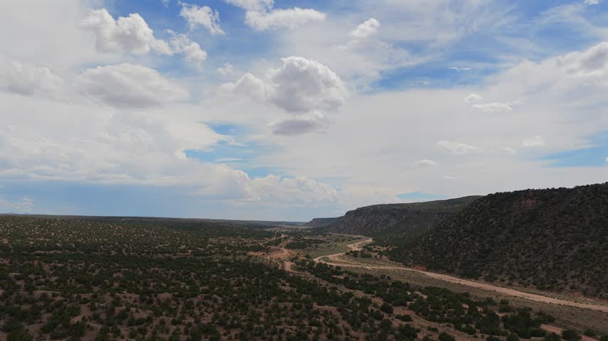 Aerial view of high desert terrain with vast open landscapes and scattered shrubs under a cloudy sky in Santa Fe, New Mexico, United States.