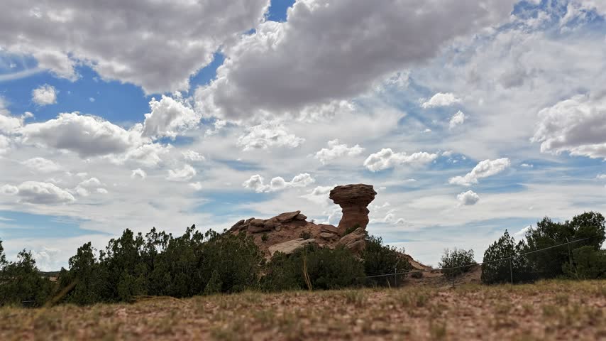 Aerial view of the iconic Camel Rock formation with white fluffy clouds in the sky in Santa Fe, New Mexico, United States.