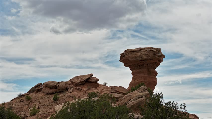 Aerial view of the iconic Camel Rock sandstone formation with moving clouds in the desert landscape of Santa Fe, New Mexico, United States.