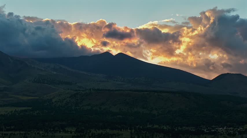 Aerial view of the San Francisco Peaks with fiery dramatic clouds during sunset near Flagstaff, Arizona, United States.