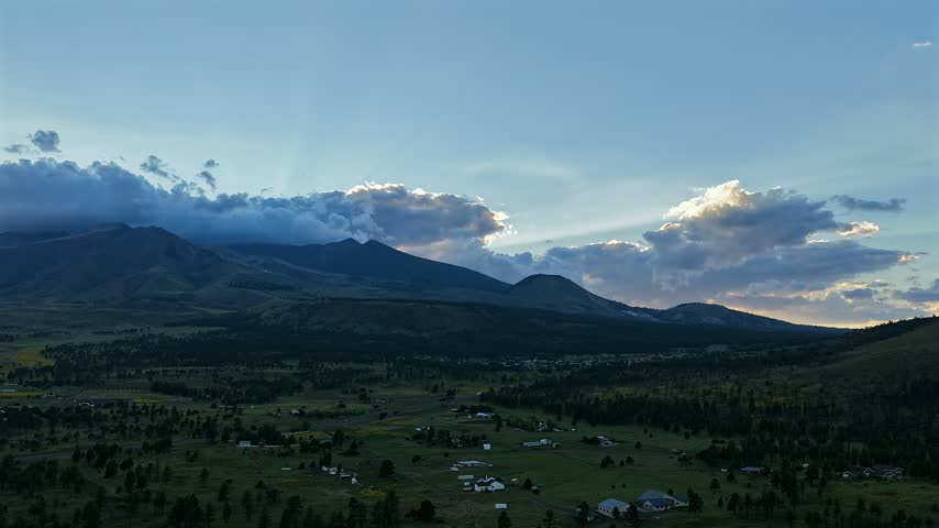 Aerial view of the San Francisco Peaks at sunset with dramatic clouds over the forest landscape in Flagstaff, Arizona, United States.