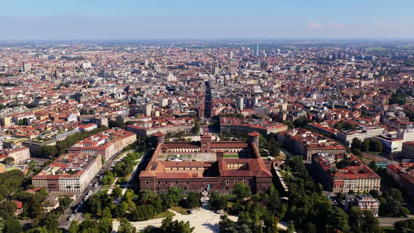 Forward flight from Parco Sempione toward Castello Sforzesco and its courtyards in Milan, Italy, Via Dante leading to Milan Cathedral and Torre Velasca on a sunny day