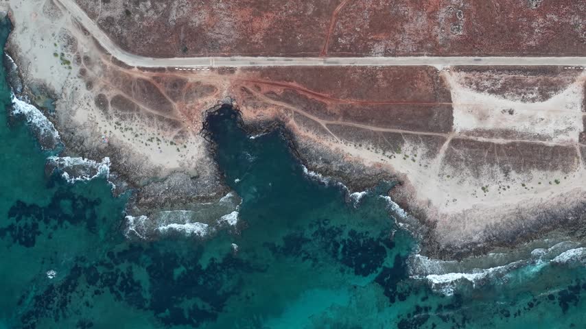 Aerial view of the rugged coastline with turquoise waters and rocky shores in Sicily, Sicily, Italy.