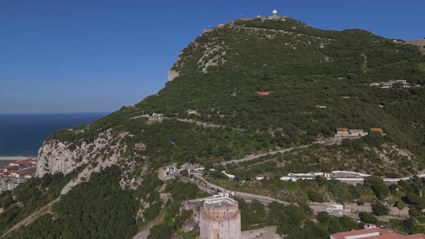 Gibraltar, Gibraltar - 17 July 2025: Aerial view of Moorish Castle on the lush green slopes of the Rock of Gibraltar overlooking the sea.