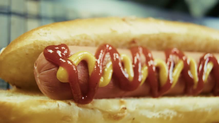 Appetizing Hot Dog With Ketchup And Mustard In Bun During Fast Food Meal And Street Food Snack. Culinary Concept Highlighting Fast Food And Delicious Eating. Food Scene Showing Hot Dog. Our Hot Dog Delivers Savory Taste. Every Meal Moment Ensures Delicious Flavor
