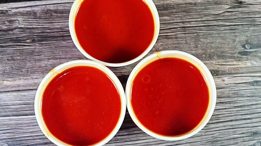Three classic tomato-based seafood soup cups, combines savory garlic, aromatic herbs, and fresh seafood in a vibrant, rich broth, a hot bisque shrimp sea food soup