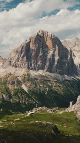 Zoom in of Tofana mountain peak and Cinque Torri rock formation under cloudy sky in Dolomites. Scenic landscape view of majestic limestone cliffs, pine forest and alpine meadows in Italian Alps.