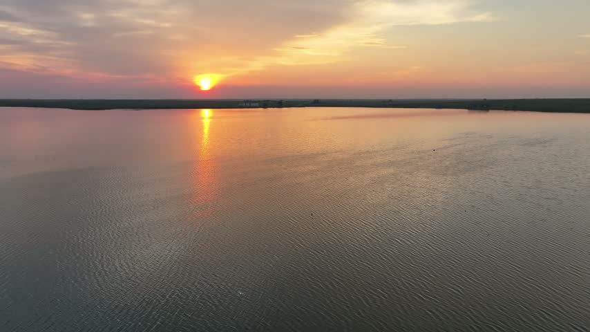 Golden Sunrise Reflecting Across Calm Water at Rice Lake North Dakota