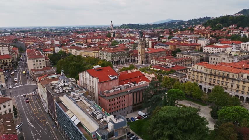 Aerial drone view of Teatro Gaetano Donizetti in Bergamo, Italy, showcasing the historic opera house, elegant architectural details, surrounding Piazza Cavour, and vibrant city center.