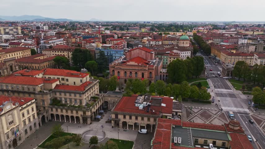 Aerial drone view of Teatro Gaetano Donizetti in Bergamo, Italy, showcasing the historic opera house, elegant architectural details, surrounding Piazza Cavour, and vibrant city center.