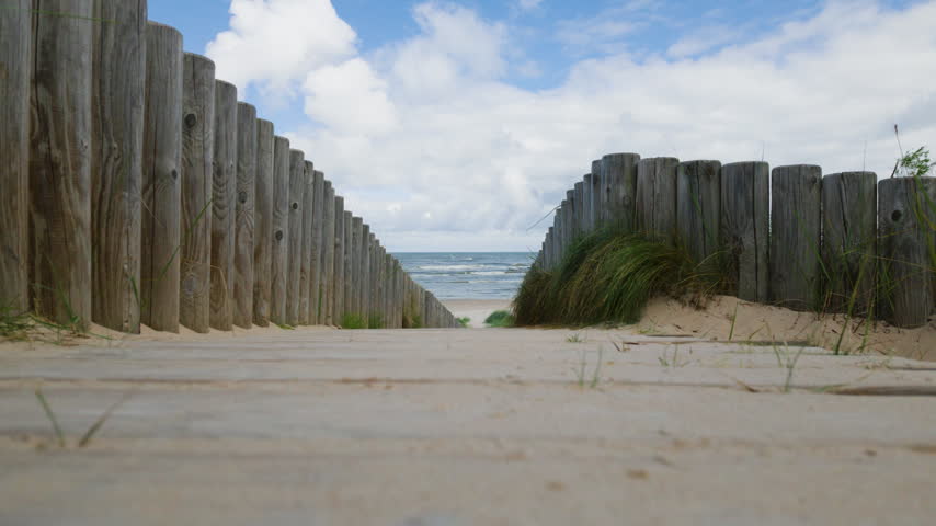 Wooden boardwalk path leading to sandy beach and ocean