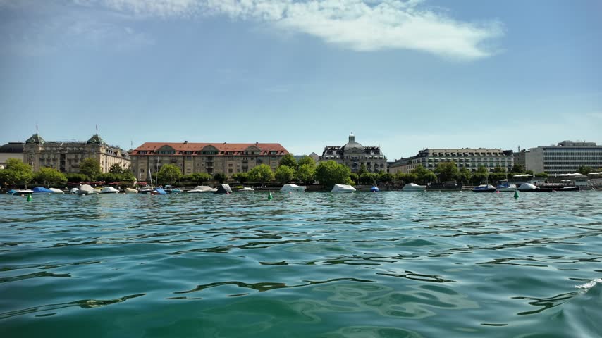 Zurich and the view from Lake Zurich in Switzerland. Buildings along the lakeshore are visible in the distance.