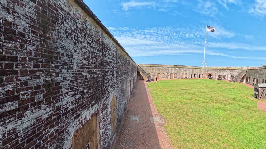 Weathered brickwork gives way to Fort Macon courtyard and a cannon on the rampart.