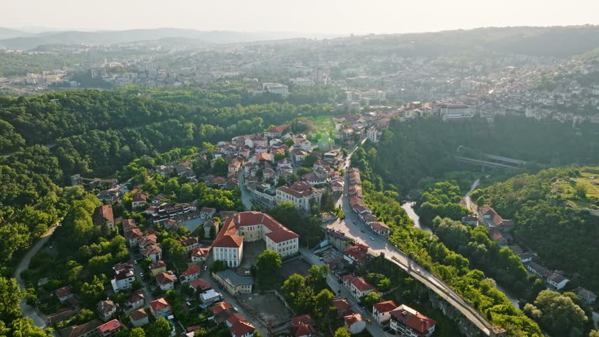 Veliko Tarnovo old town aerial view hill landscape Yantra river valley sunset light historic Bulgaria drone footage