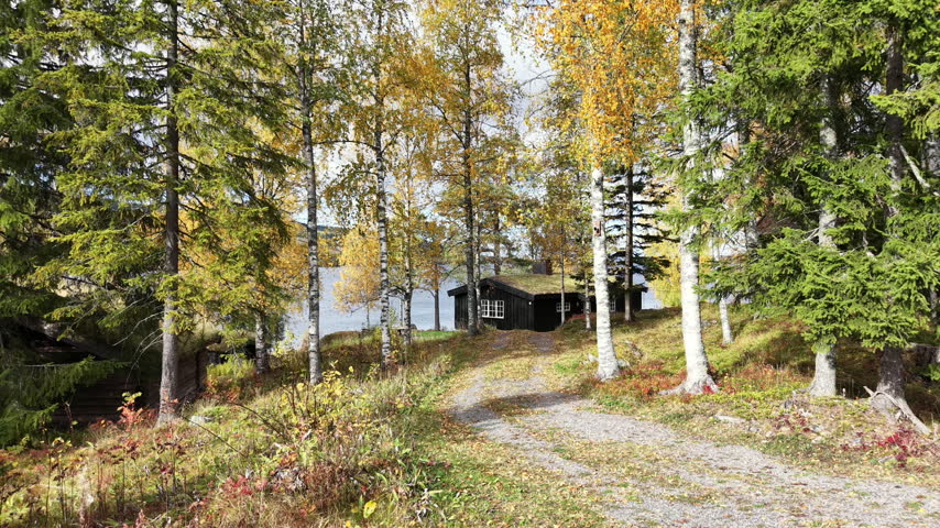 Aerial view of traditional Norwegian cabin on the bank of Eina river in autumn