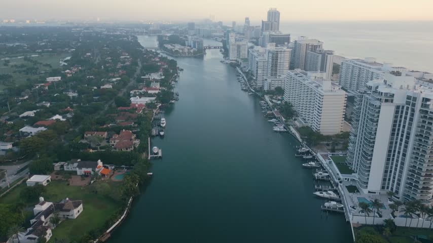 Aerial view of the waterway in Miami Beach with luxury high-rise buildings, private docks, and boats along the shore in Miami Beach, Florida, United States.