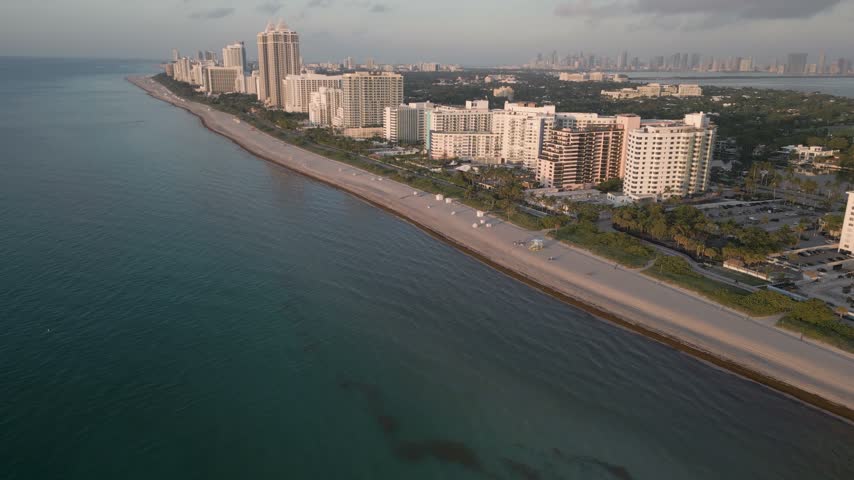 Aerial view of the Miami Beach coastline featuring high-rise hotels and residential buildings along the sandy shore with the Atlantic Ocean in Miami Beach, Florida, United States.