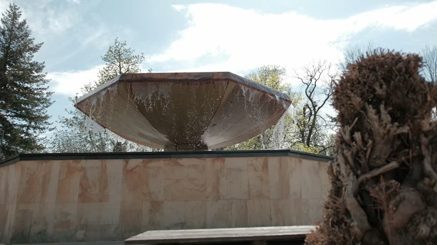 Large mushroom shaped fountain with water overflowing in a public park in Ciechocinek, Poland