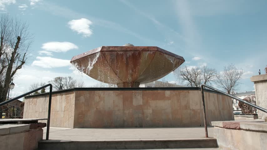 Mushroom shaped stone fountain with water overflowing in a public park in Ciechocinek, Poland