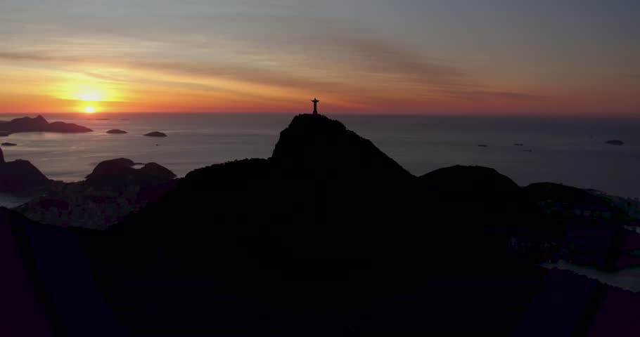 Aerial view of Christ the Redeemer statue silhouetted against a vibrant sunset over the Atlantic Ocean in Rio de Janeiro, Rio de Janeiro, Brazil.