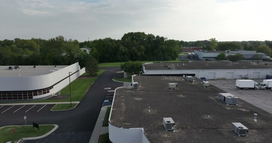 Aerial view of industrial buildings with flat roofs, parking lots, and parked trucks in Indianapolis, Indiana, United States.