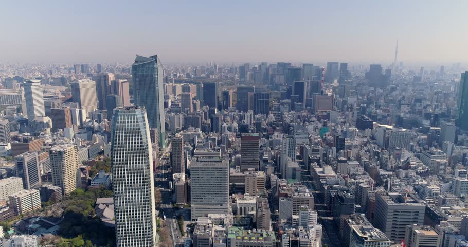 Aerial view of the dense urban skyline of Tokyo featuring modern skyscrapers, office buildings, and residential areas stretching towards the horizon in Tokyo, Tokyo, Japan.