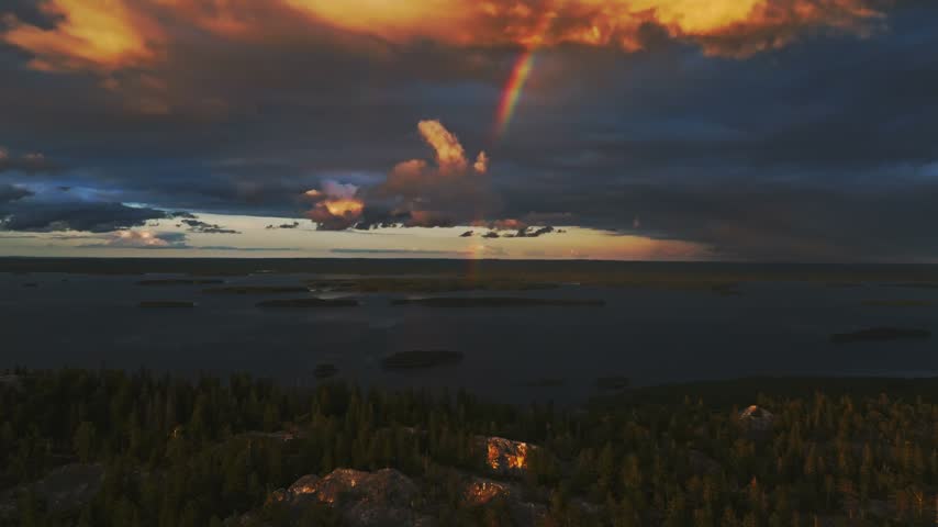 Aerial view of Koli National Park with a rainbow over the lake and forest during sunset in Lieksa, North Karelia, Finland.