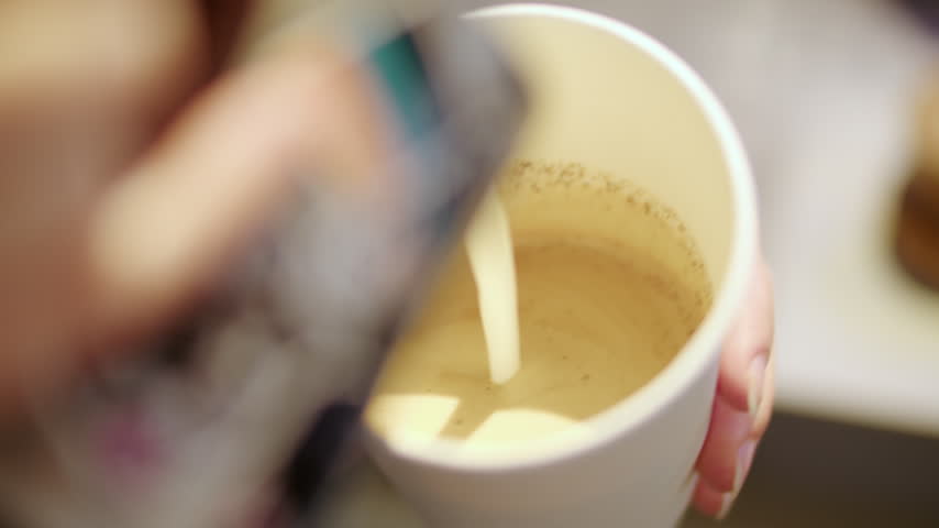 Barista Steaming Milk in Metal Pitcher for Coffee Preparation