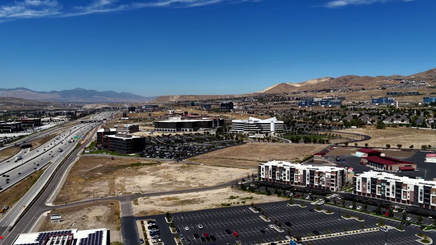 Aerial view of Silicon Slopes technology corridor with modern office buildings, highway infrastructure, and suburban development in Lehi, Utah, United States.