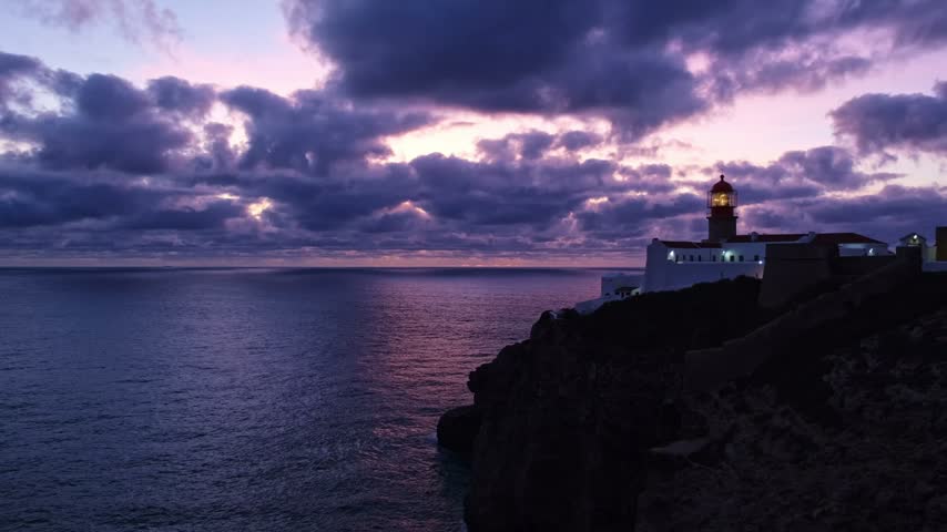 View of the Lighthouse of Cabo de Sao Vicente in Sagres, Algarve, Portugal, at dusk with Atlantic edge and Atlantic ocean