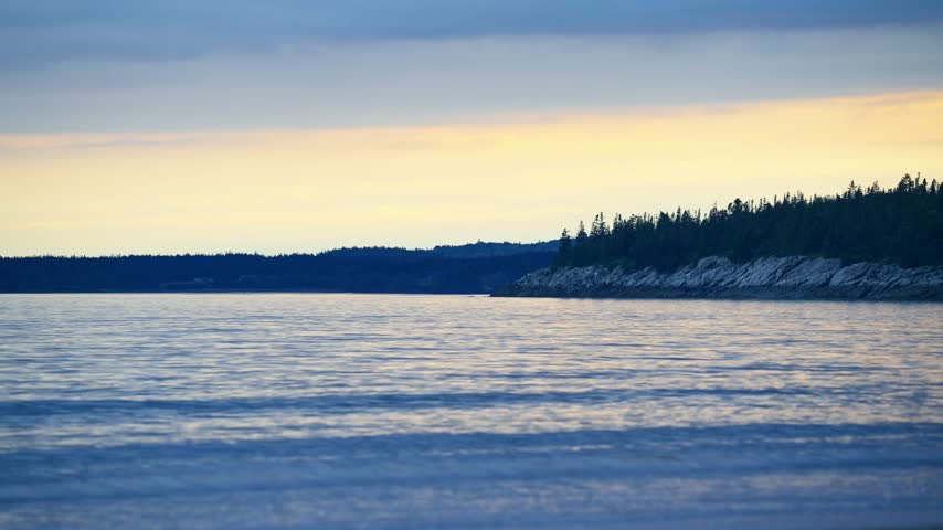 New River Beach Provincial Park sandy tidal shoreline under dramatic overcast twilight skies along the Bay of Fundy, New Brunswick.