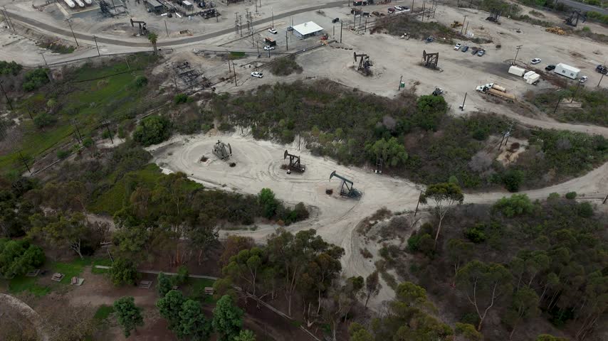 Aerial view of oil pumps operating in the Baldwin Hills oil field, surrounded by dry terrain and sparse vegetation in Los Angeles, California, United States.