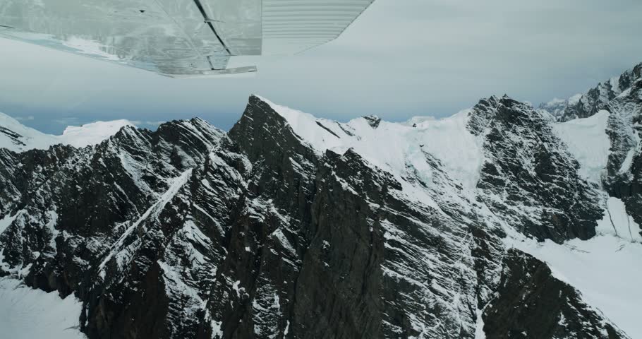 Aerial view of Mount McKinley with snow-covered rugged peaks seen from a small plane in Denali Borough, Alaska, United States.