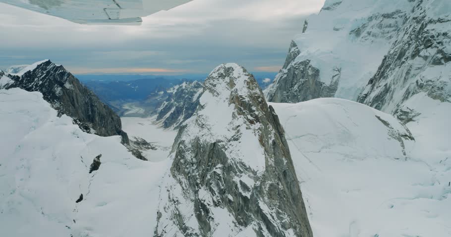 Aerial view of Mount McKinley surrounded by snow-capped peaks and glaciers seen from a small plane in Denali Borough, Alaska, United States.
