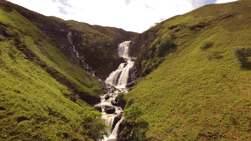 Beautiful Scottish Waterfall Flowing Over Rocky Cliffs in Wild Isle of Skye Landscape Cinematic 4K Footage