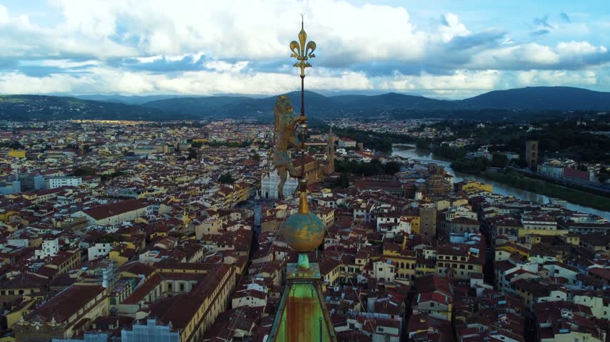 Aerial view of Palazzo Vecchio with its iconic tower and the surrounding historic rooftops of Florence under a cloudy sky in Firenze, Toscana, Italy.