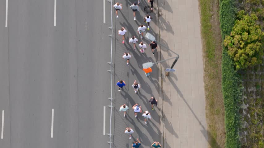 Aerial view of a group of runners participating in a race on an asphalt road in Kaunas, Kaunas County, Lithuania.