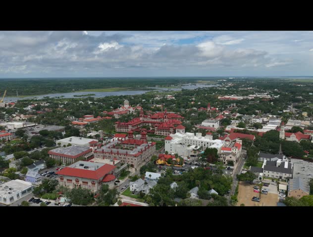 Aerial view of the historic city center featuring the Lightner Museum and Flagler College buildings under a cloudy sky in St. Augustine, Florida, United States.