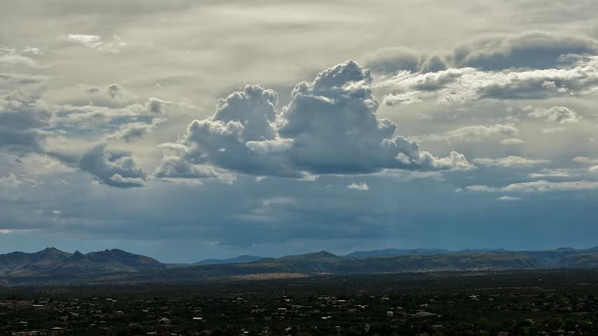 Aerial view of dramatic golden and silver clouds moving over the desert landscape and town of White Rock, NM, United States.