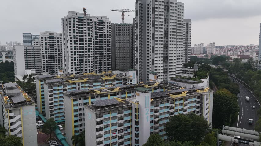 Aerial view of Tenteram Peak residential complex with high-rise HDB apartment blocks, a construction crane, and a nearby highway in Singapore, Singapore.