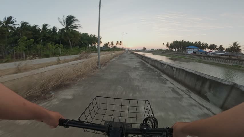 First Person View Cycling on Rural Path at Sunset