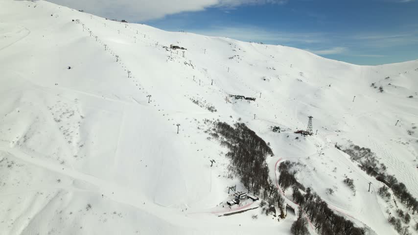 Aerial view of the snow-covered slopes of Cerro Catedral with ski lifts and chairlifts visible against the mountain landscape in Bariloche Department, Rio Negro Province, Argentina.