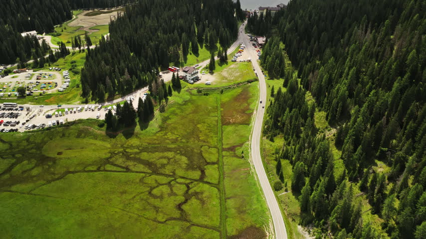 Parking Area Lines A Forested Mountain Road Near Tre Cime di Lavaredo In The Misurina Area Of Belluno, Northern Italy. Aerial Pullback Shot