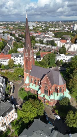 Aerial view of St. Johannis Kulturkirche Altona surrounded by urban buildings and lush trees in Hamburg, Hamburg, Germany.