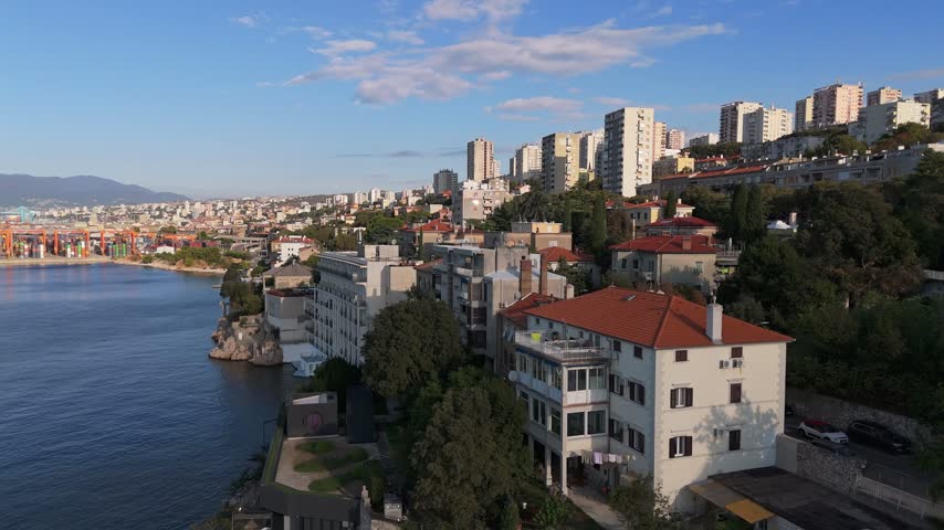 Aerial view of the coastal city of Rijeka with its port infrastructure, residential buildings with red roofs, and the Adriatic Sea in Rijeka, Primorje-Gorski Kotar, Croatia.