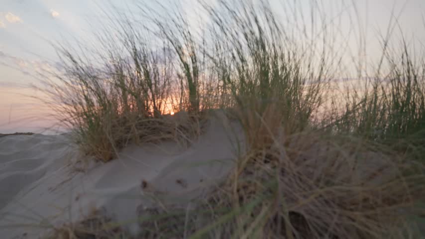 Sunset over sandy beach dunes sand sea and sun